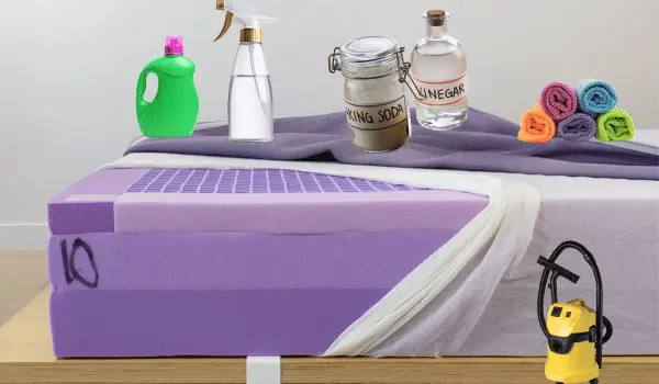 Cleaning supplies including baking soda, vinegar, detergent, spray bottle, towels, and a vacuum placed on a Purple Mattress.