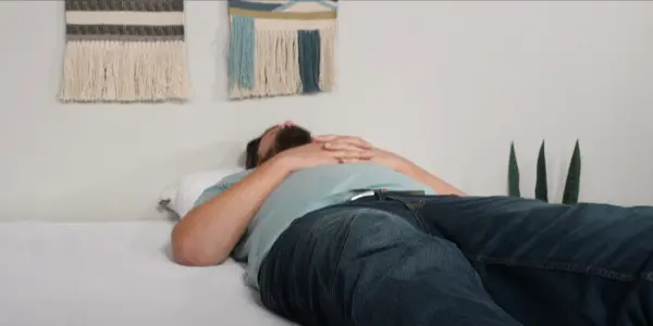 A heavy person lying on a Purple mattress, demonstrating its support and suitability for individuals with a higher body weight.