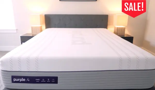 Purple 4 mattress on a bed frame in a bedroom with a "SALE!" tag in the top right corner.