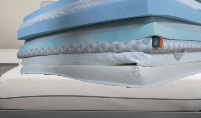 A stack of different mattress toppers placed on a Purple Mattress showcases various options for enhancing comfort and support.