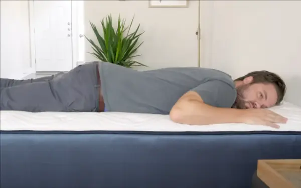 A heavy stomach sleeper lying on the BigFig Mattress, showcasing its support and suitability for larger body types.